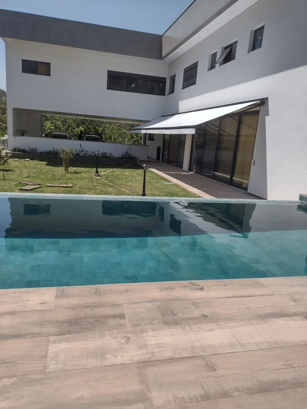 Toldo articulado motorizado em varanda de residência